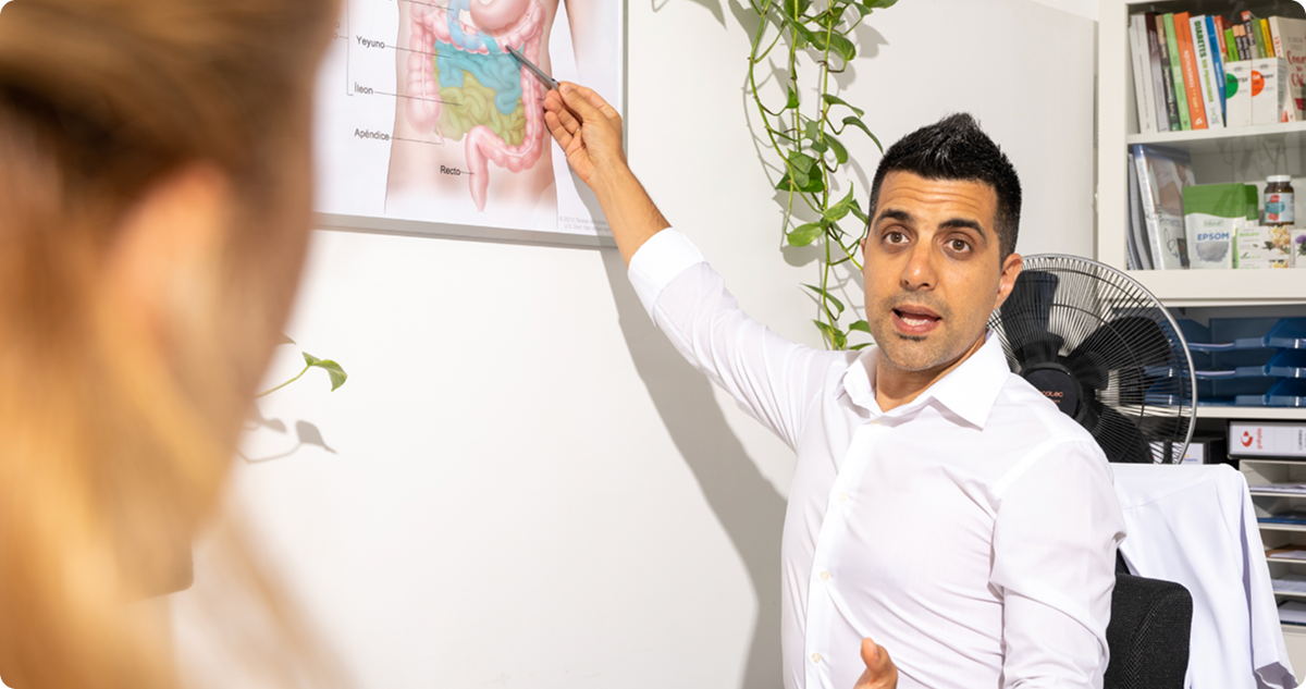 Especialista explicando el sistema digestivo durante una consulta de bienestar integral